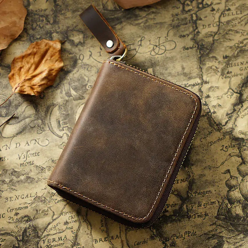 Zippered Small Leather Wallet in Dark Brown on a table at Addison West