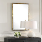Sutcliffe Vanity Mirror on a beige wall above a table at Addison West