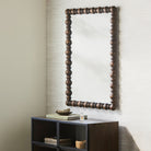 Brennan Accent Mirror on a beige wall above a table at Addison West