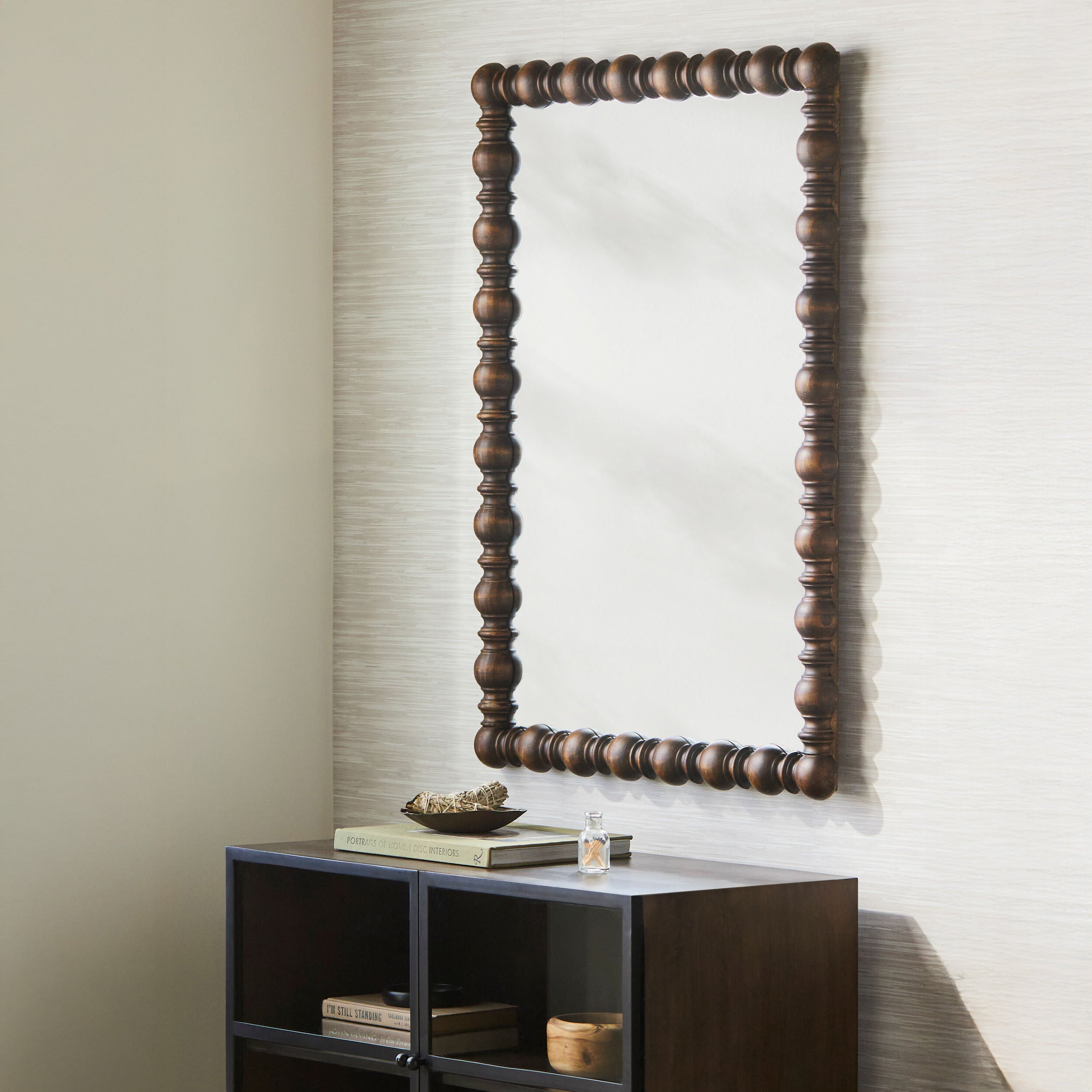 Brennan Accent Mirror on a beige wall above a table at Addison West