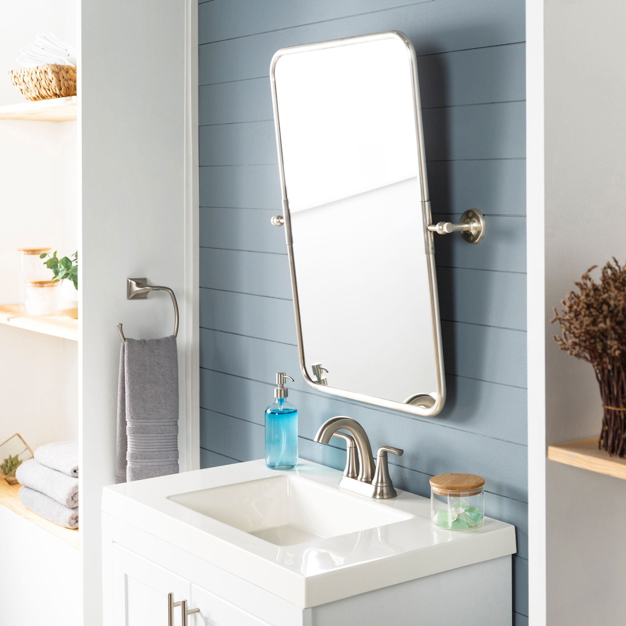Burnish Accent Mirror in Antiqued Silver on a blue wall in a bathroom at Addison West