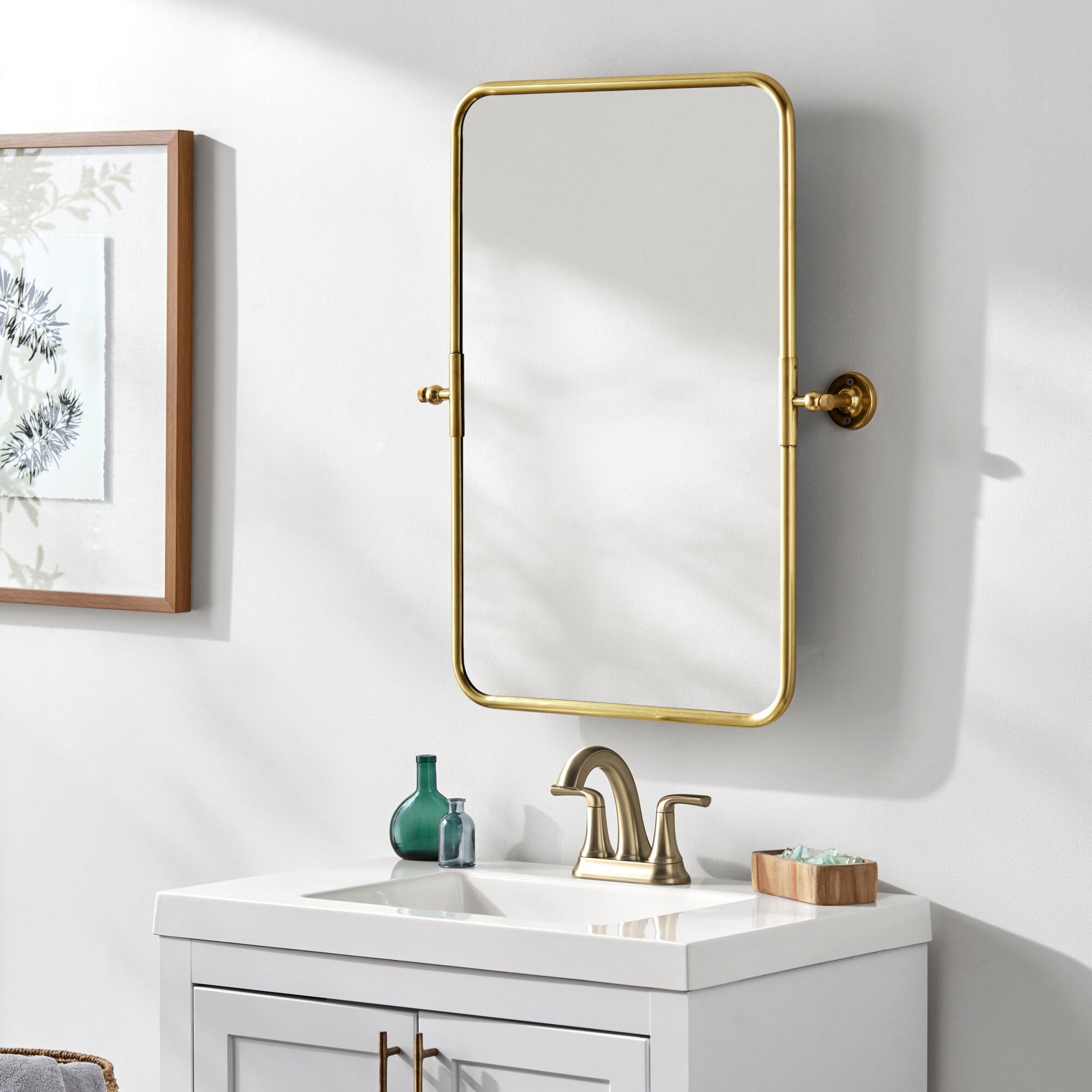 Burnish Accent Mirror in Antiqued Gold on a white wall in a bathroom at Addison West