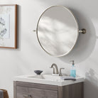Burnish Round Accent Mirror in Antiqued Silver on a white wall in a bathroom at Addison West
