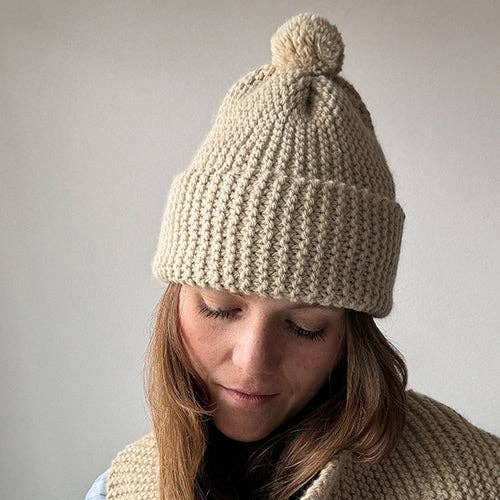 Knitting Craft Kit: Classic Pom Beanie in Sand on a beige background at Addison West