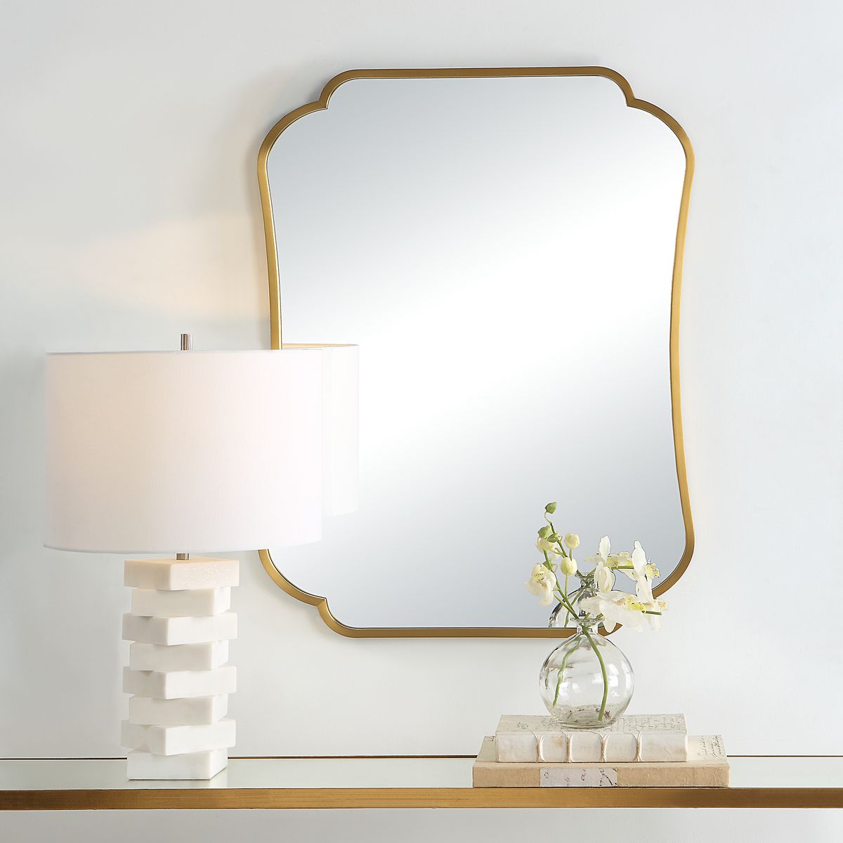 Atwell Accent Mirror on a white wall above a table at Addison West