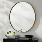 Carbondale Accent Mirror on a white wall above a table at Addison West