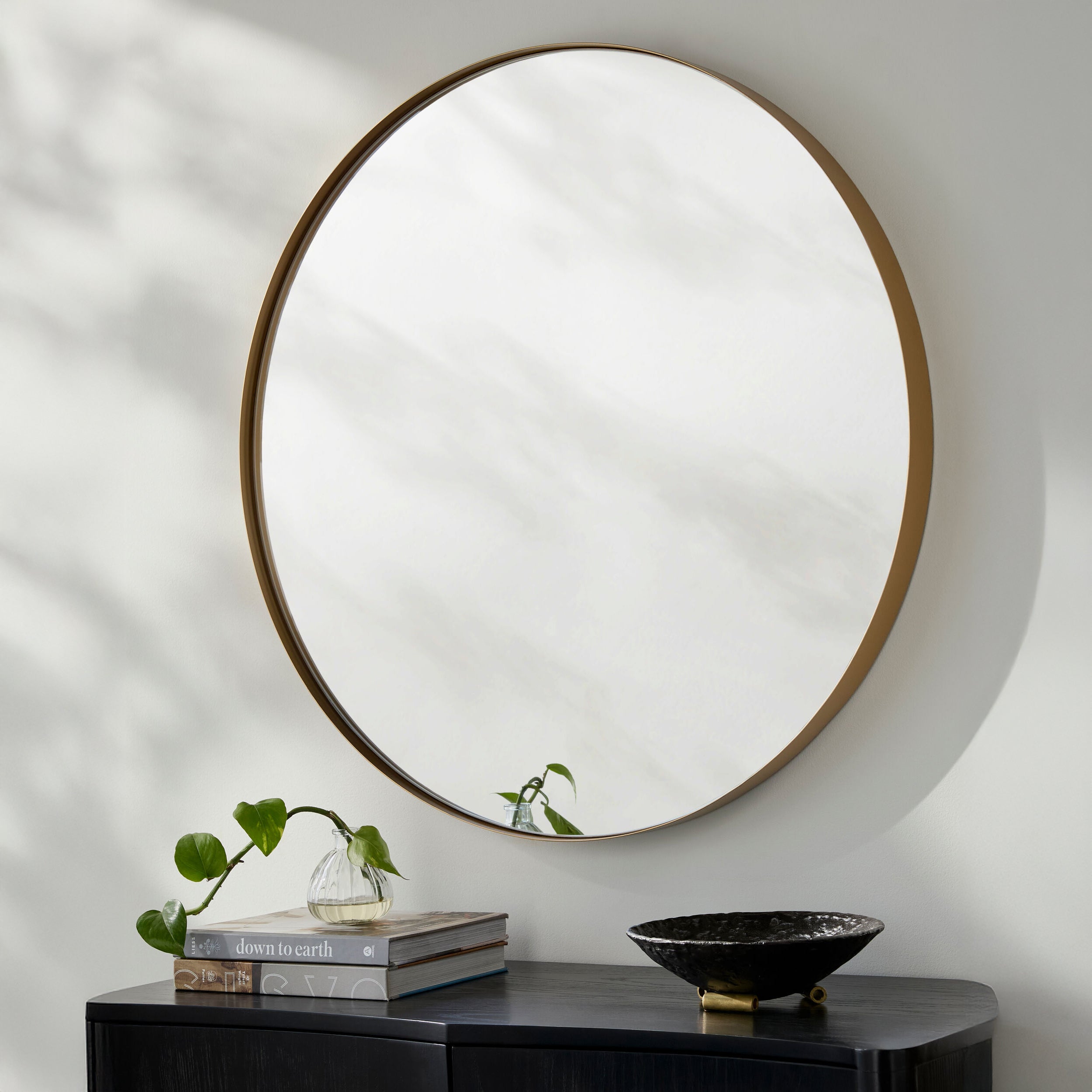 Carbondale Accent Mirror on a white wall above a table at Addison West
