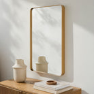 Carbondale Accent Mirror on a white wall above a table at Addison West