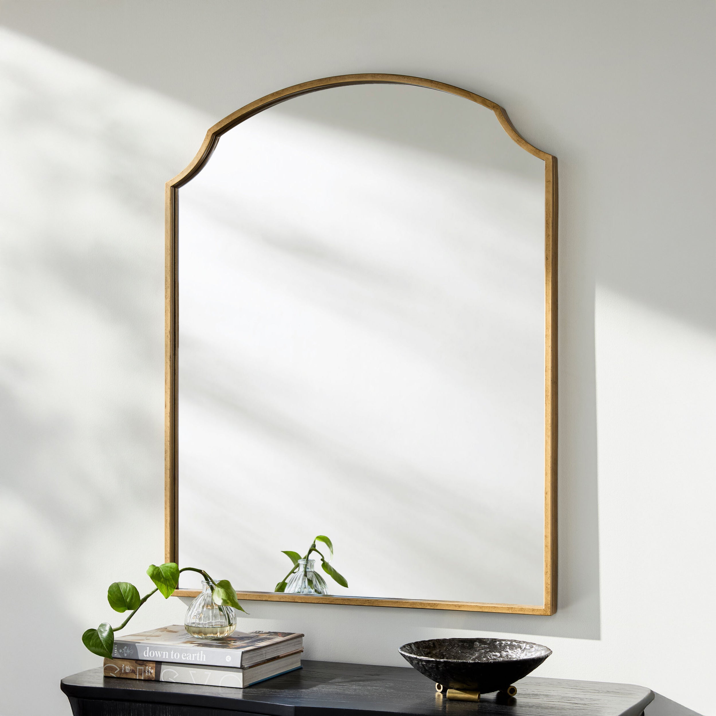 Corbin Mantel Mirror on a white wall above a table at Addison West