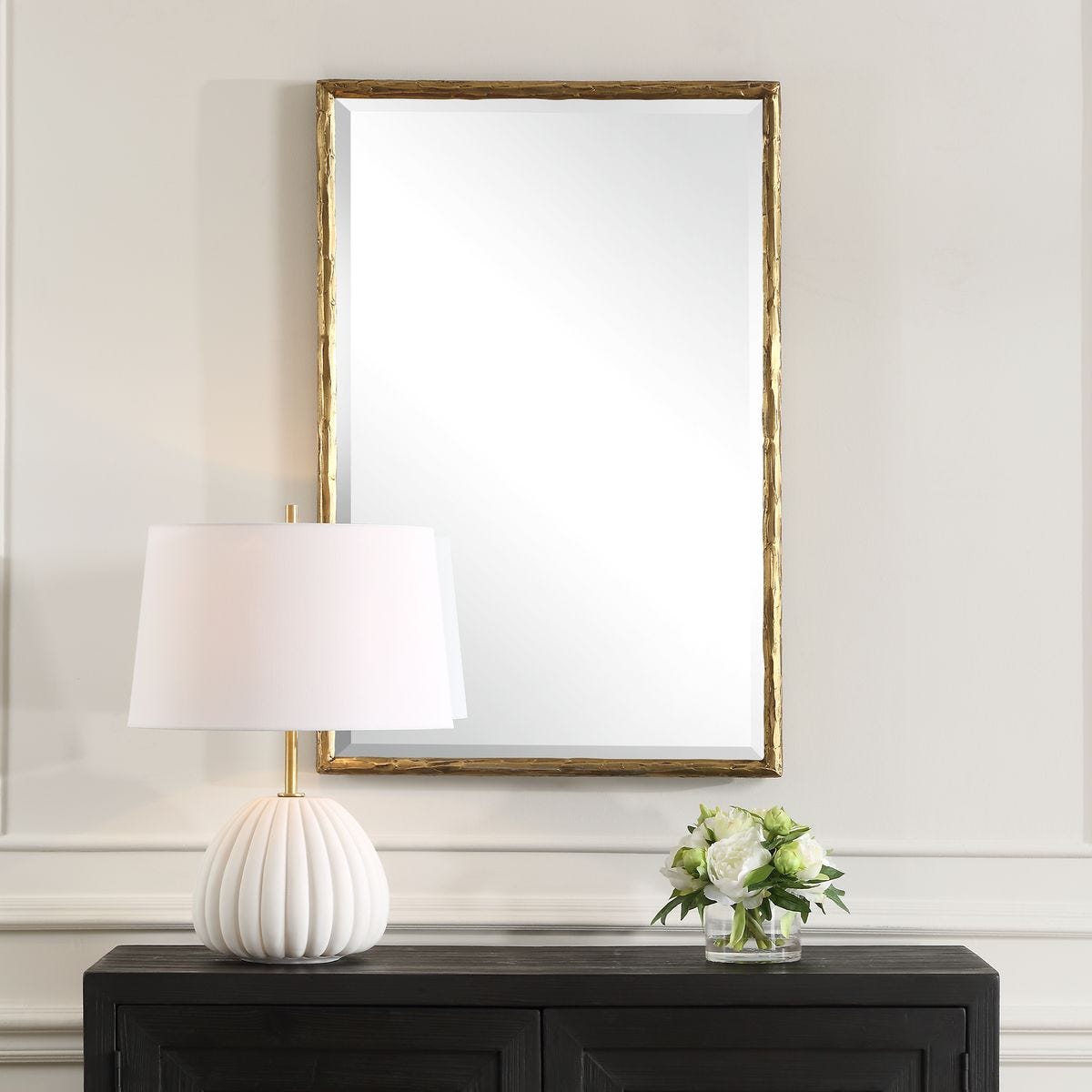 Sutcliffe Vanity Mirror on a beige wall above a table at Addison West