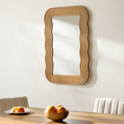 Dance Accent Mirror on a white wall above a table at Addison West