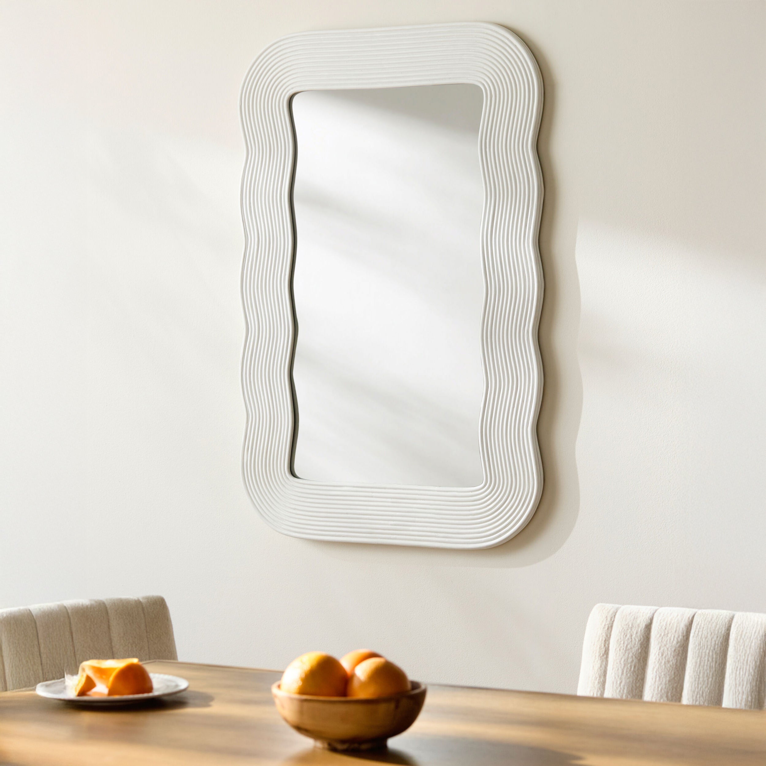 Dance Accent Mirror in White on a white wall above a table at Addison West