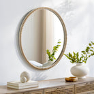 Dwarka Accent Mirror on a white wall above a table at Addison West