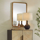Vesden Accent Mirror on a beige wall above a table at Addison West