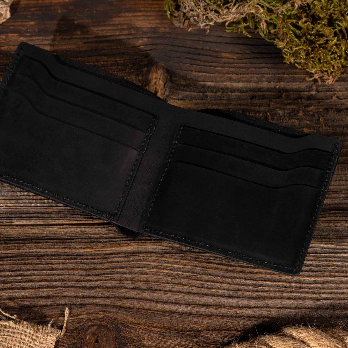 Leather Wallet Bifold Wallet in Black on a table at Addison West