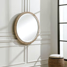 Carsten Round Accent Mirror on a white wall in a living room at Addison West
