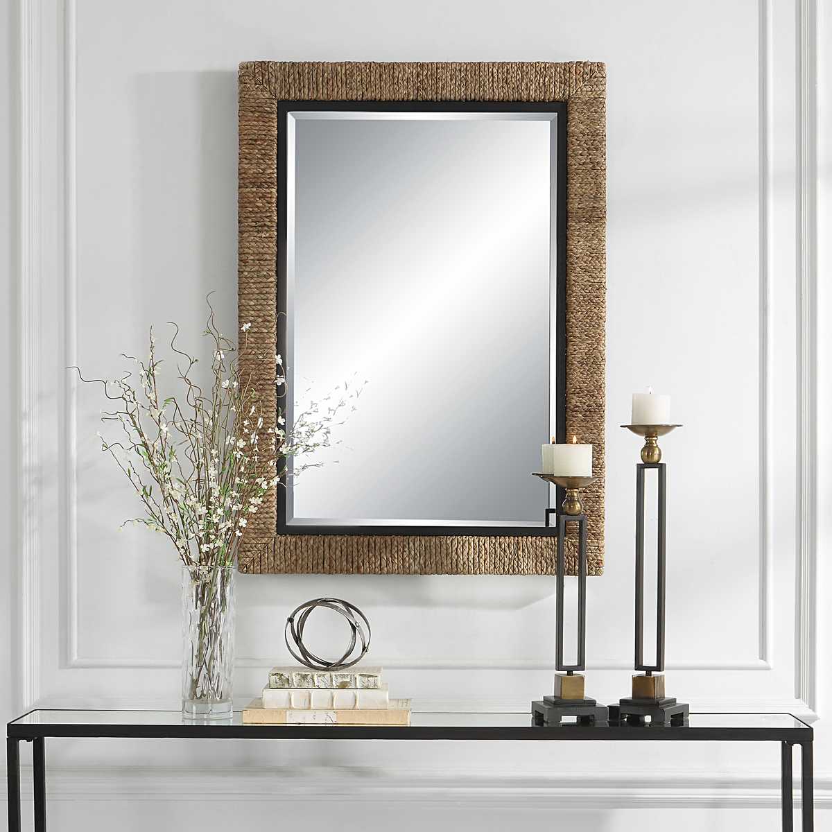 Islenne Accent Mirror on a white wall above a table at Addison West