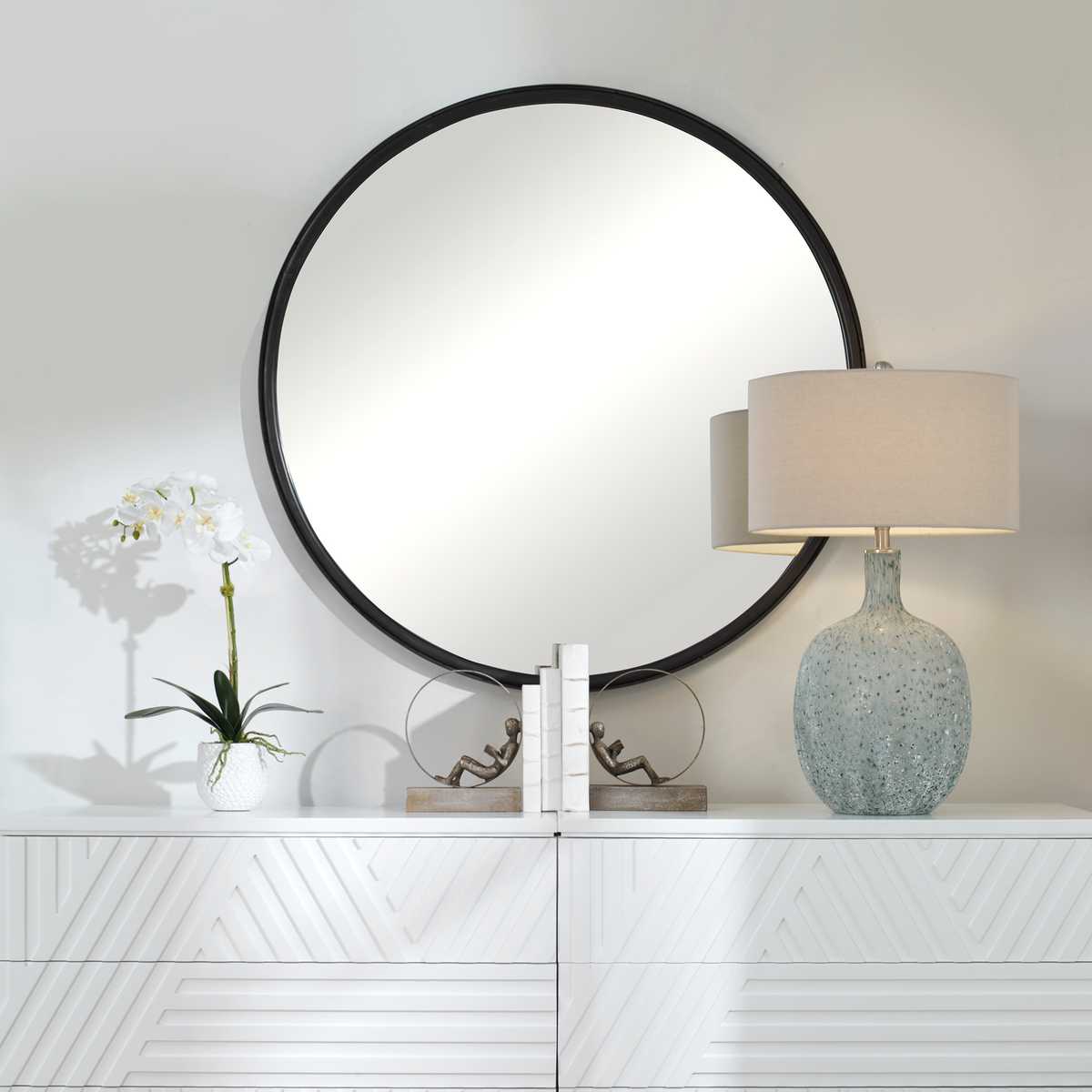 Dawsyn Round Mirror on a white wall above a table at Addison West