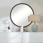 Dawsyn Round Mirror on a white wall above a table at Addison West