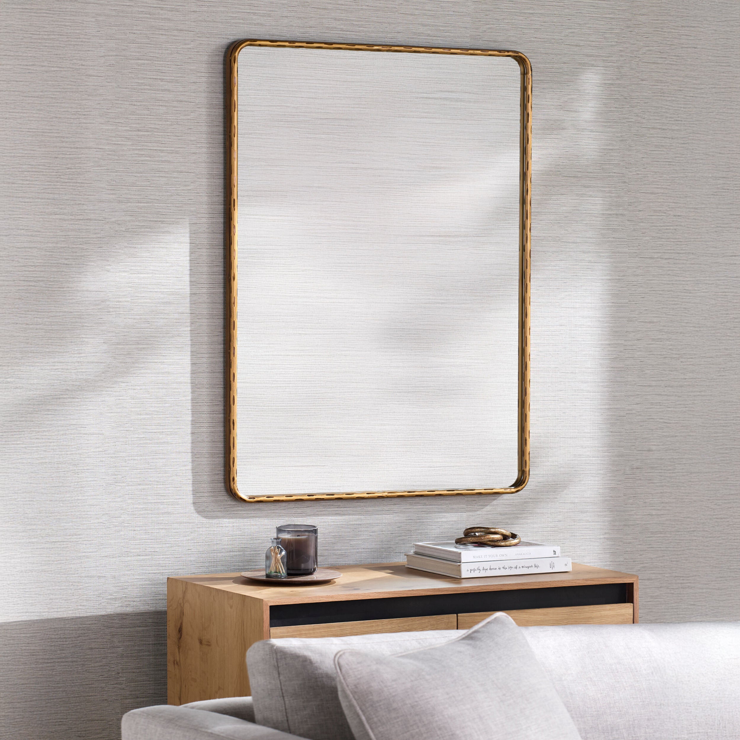 Georgine Accent Mirror on a grey wall above a table at Addison West