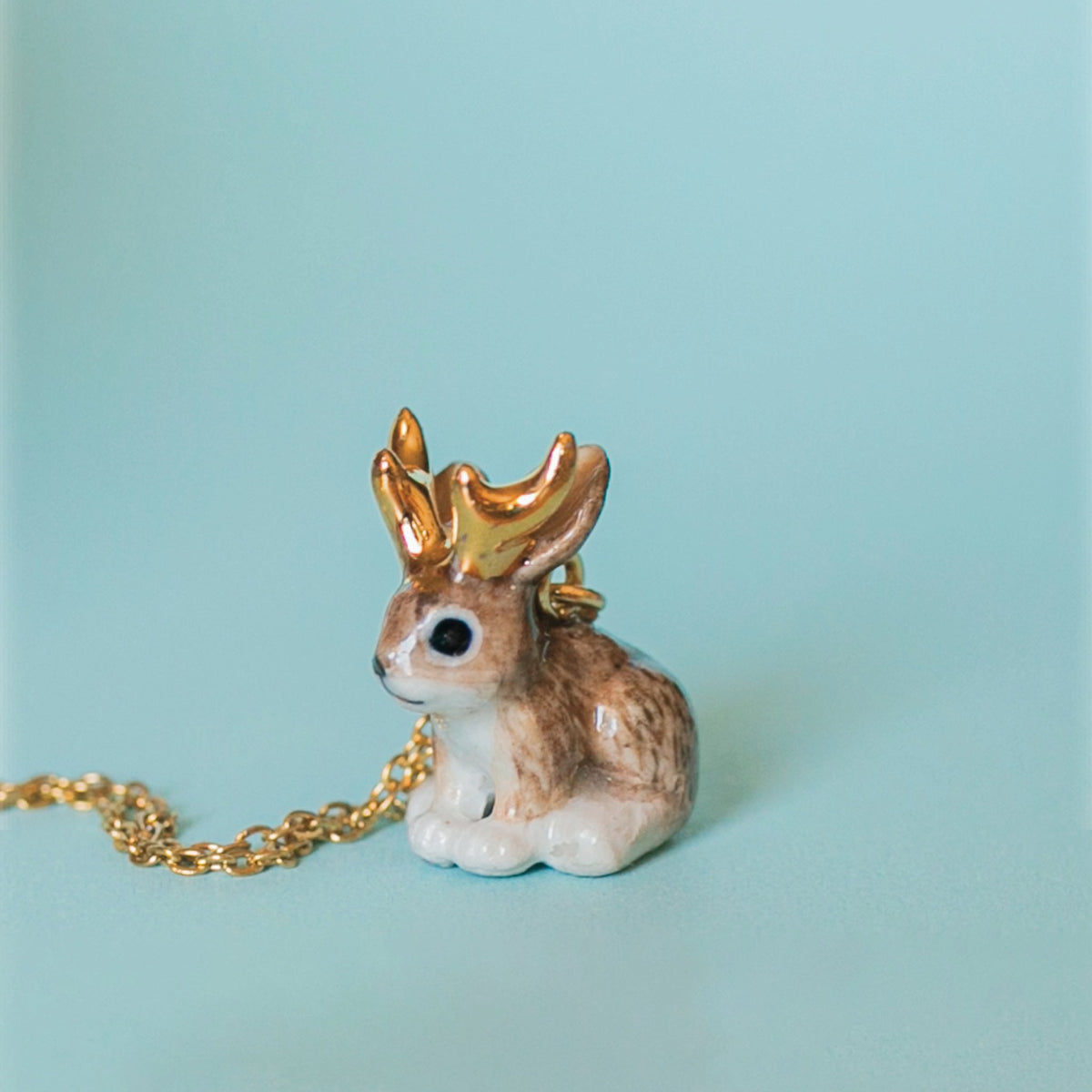 Camp Hollow Jackalope Necklace on a blue background at Addison West