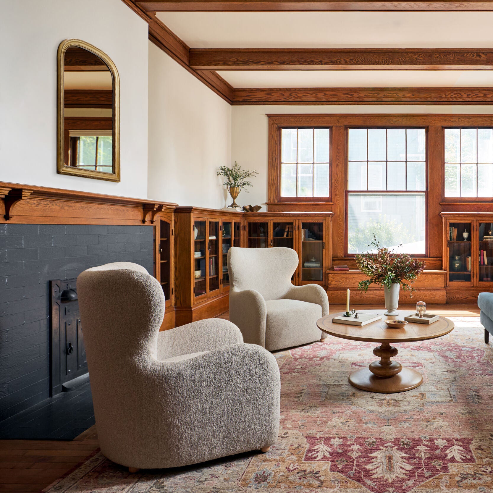 Nalanda Mantel Mirror in Antiqued Gold on a white wall in a living room at Addison West