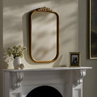 Arrendale Accent Mirror on a beige wall above a white mantel at Addison West