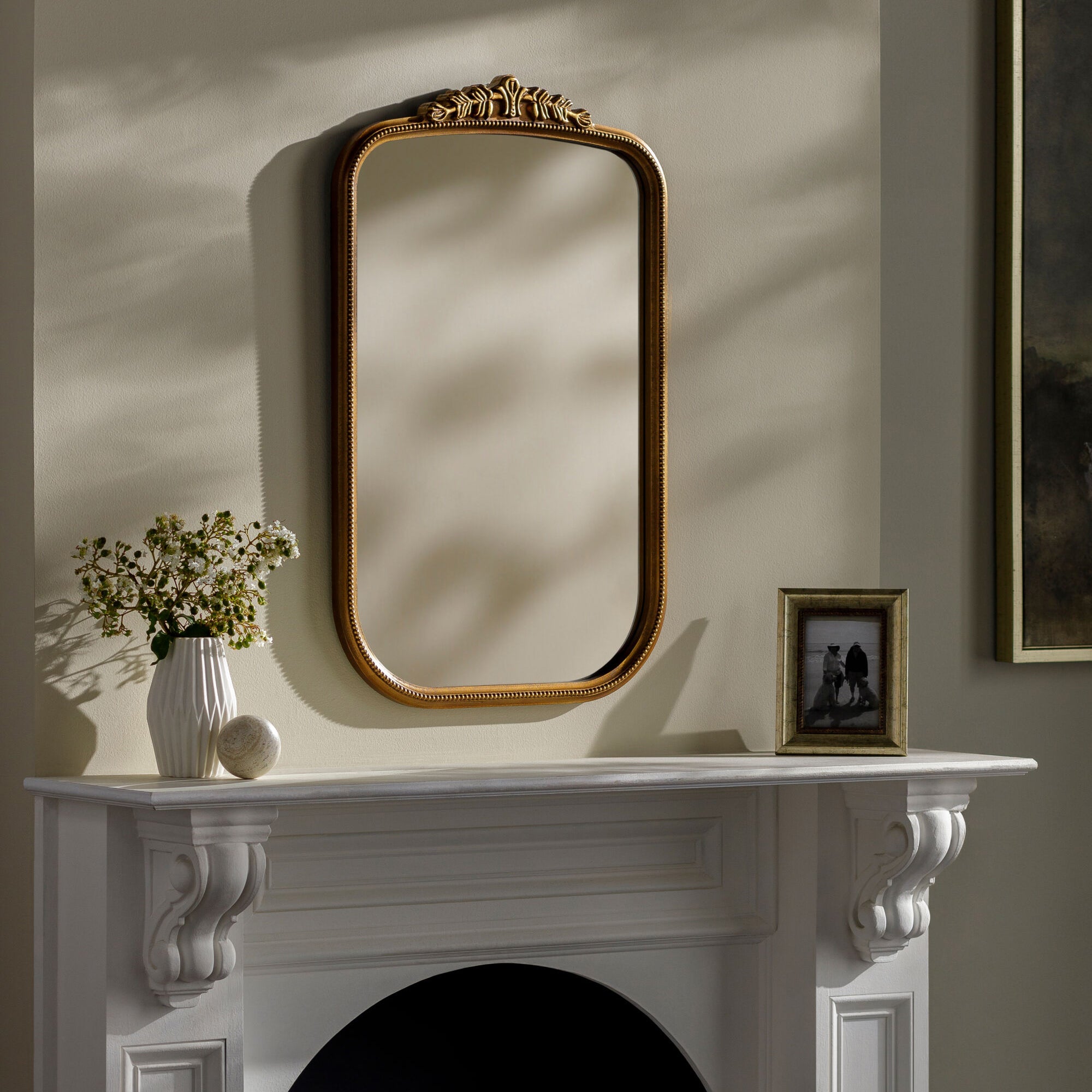Arrendale Accent Mirror on a beige wall above a white mantel at Addison West