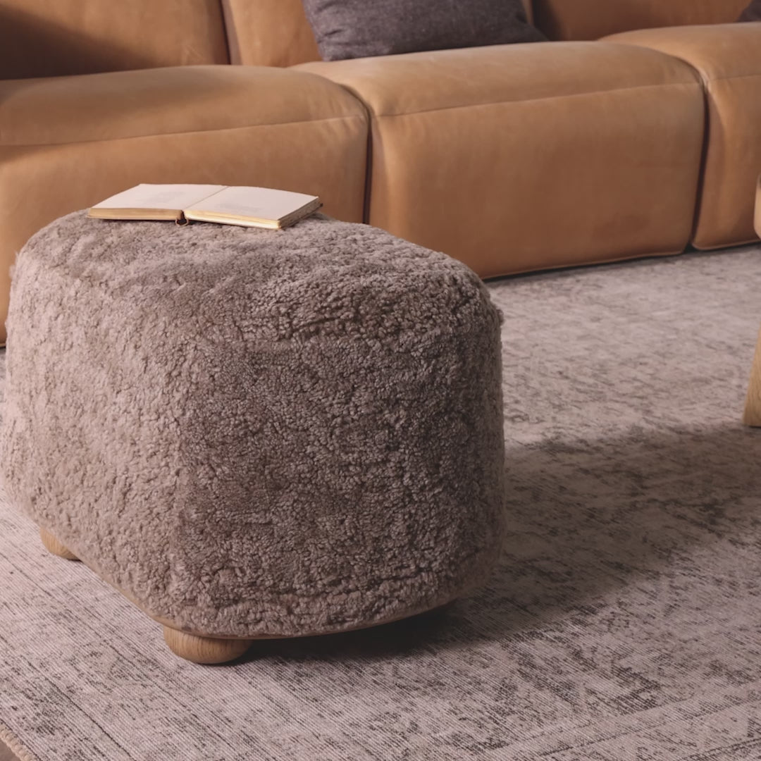 Video of Four Hands Bilbury Oval Ottoman in Taupe Shearling in a neutral living room at Addison West