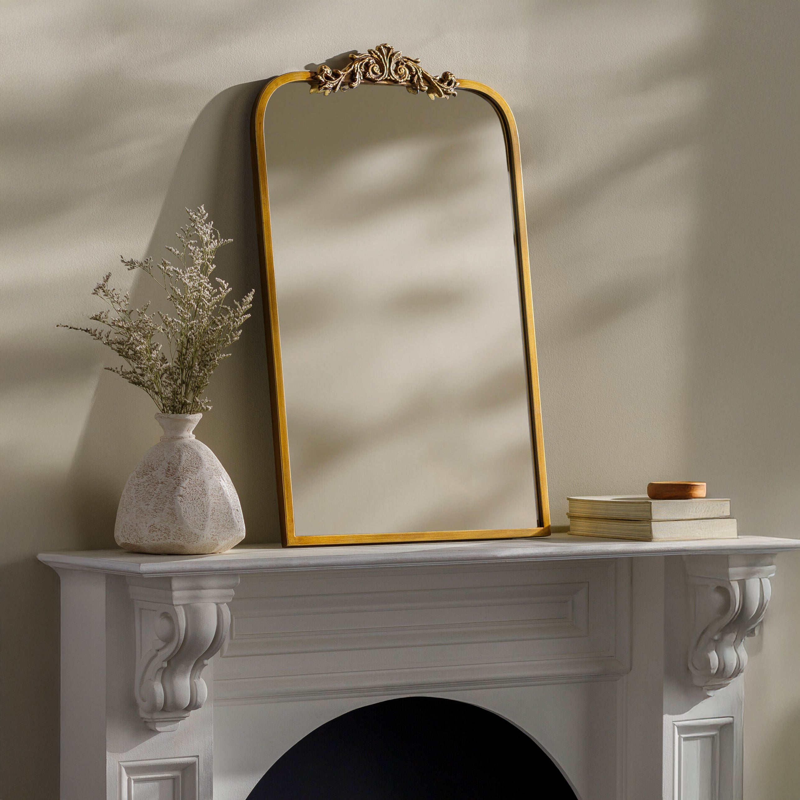 Aarlen Accent Mirror in Antiqued Gold on a white mantel at Addison West