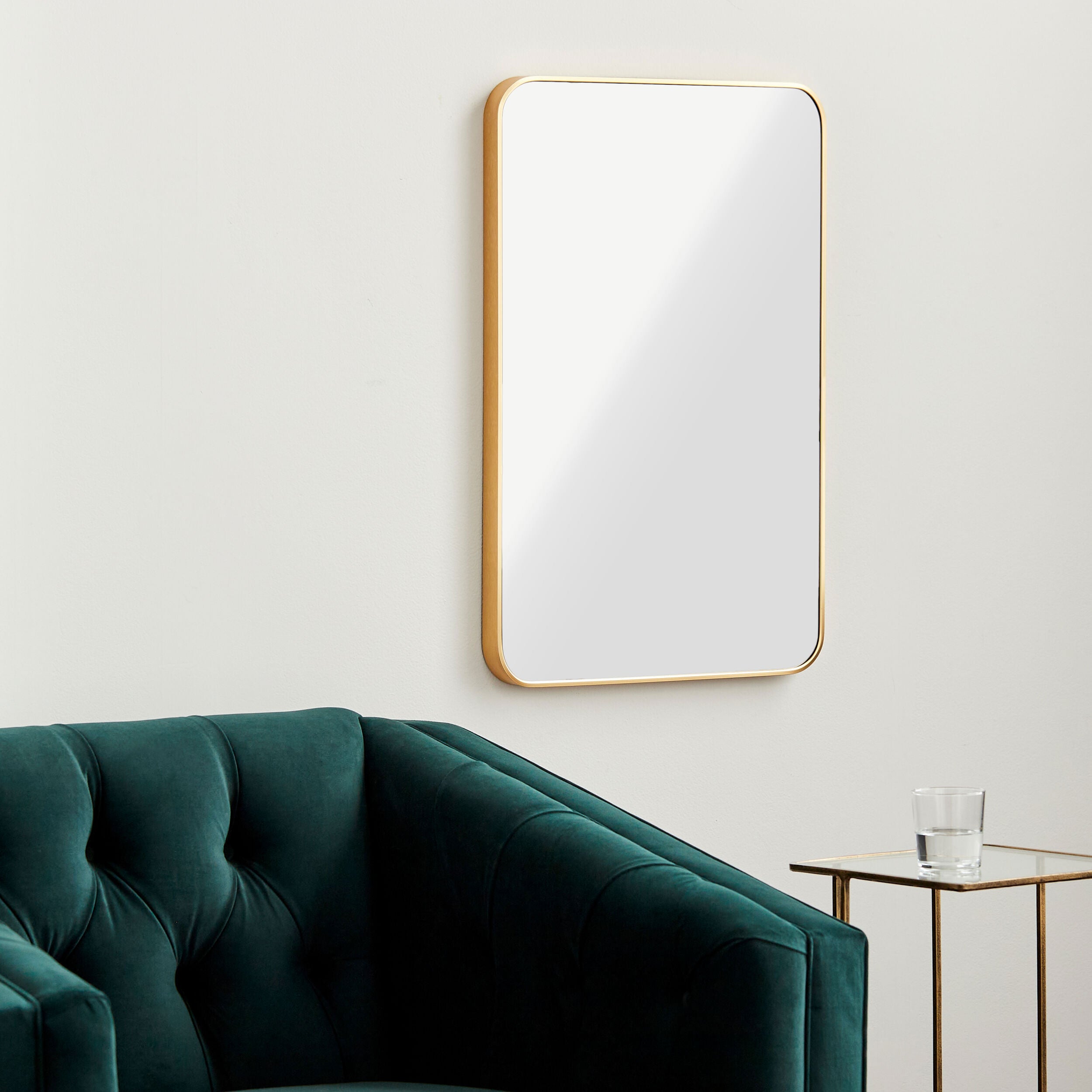 Aranya Accent Mirror on a white wall above a table at Addison West