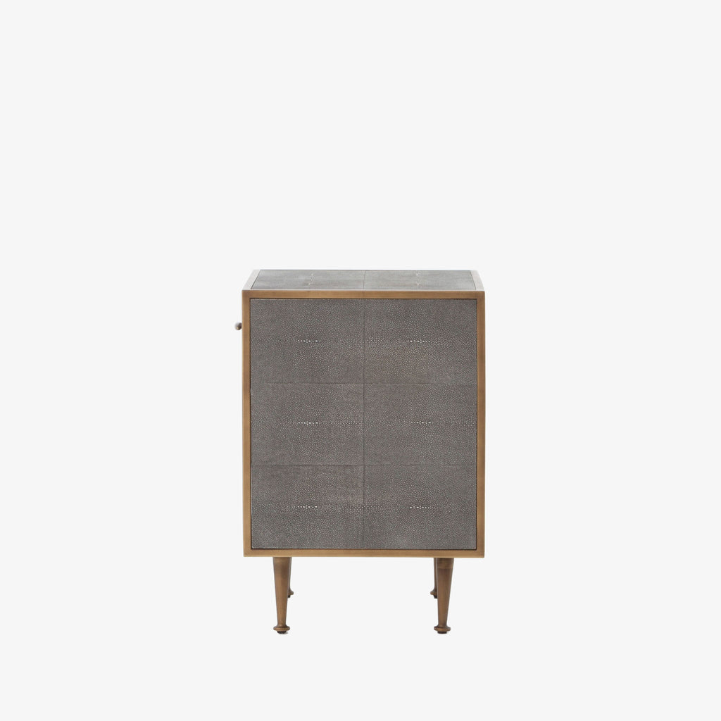 Side view of Grey shagreen nightstand with brass trim accents by four hands furniture on a white background