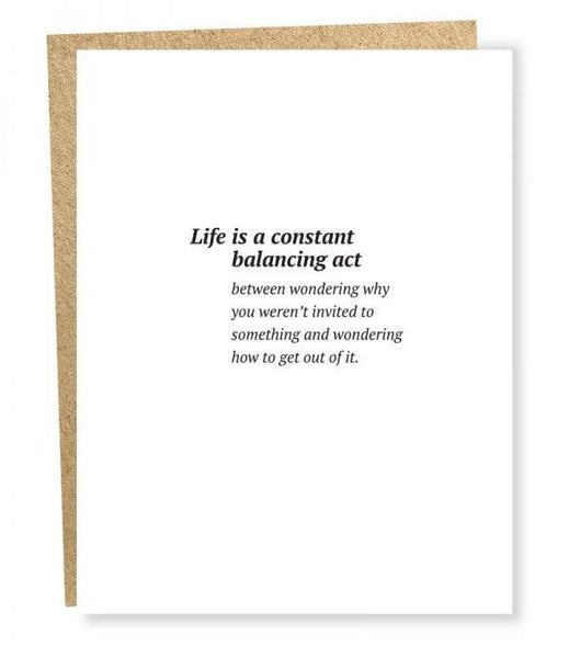 Sapling press white greeting card with saying "life is a constant balancing act between wondering why you weren't invited to something and wondering how to get out of it."
