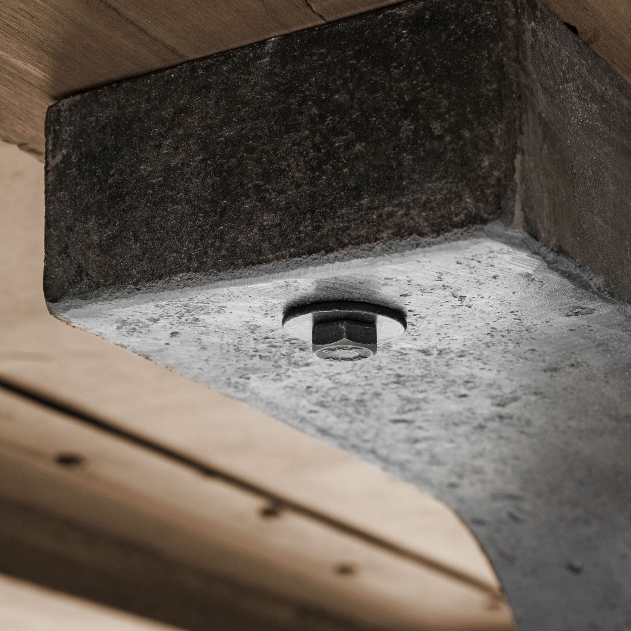 Large rectangular wood dining table with trestle style iron base on a white background