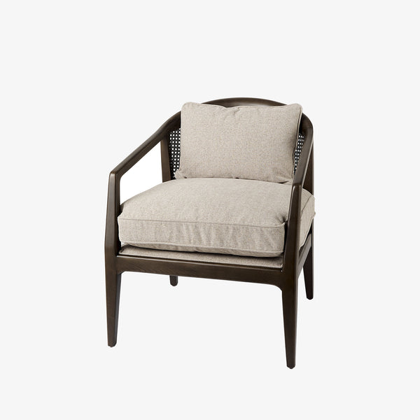 Armchair with dark brown stain and sloped arms and cane back and light beige cushions on a white background