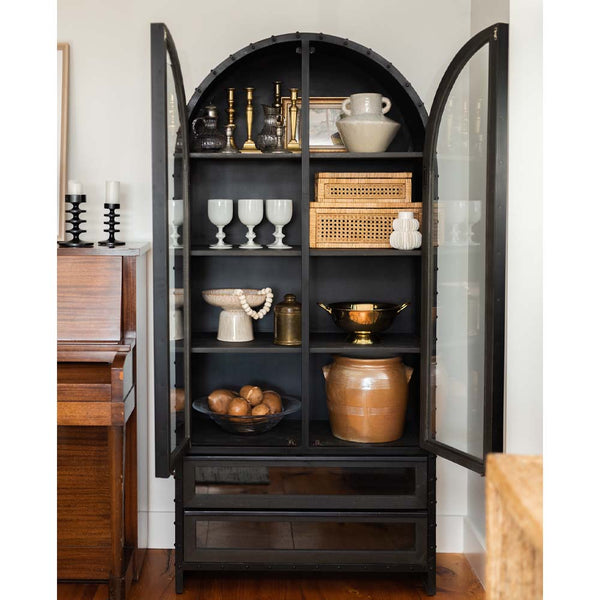 Mercana steel and glass arch top cabinet in a room with a wood floor