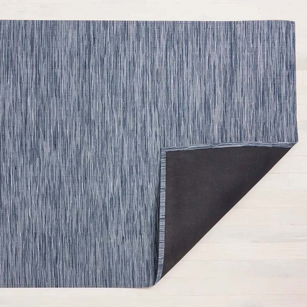 Chilewich bamboo woven floor mat in rain navy blue on a light wood floor