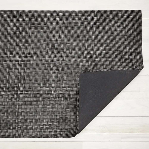 Chilewich basketweave woven floor mat in carbon on a light wood floor
