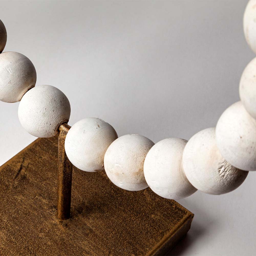 Close up of Mercana white beaded Broken Sphere Decorative Object with Gold Base on a white background