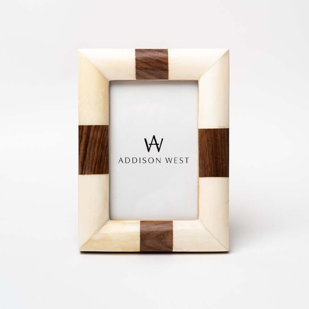 White bone picture frame with strip of wood accents on each side on a white background.