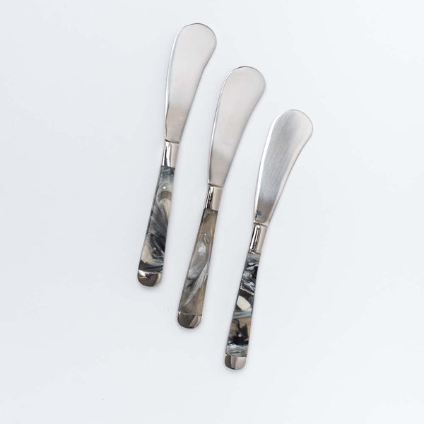 Three canape knives with resin handle on a white background