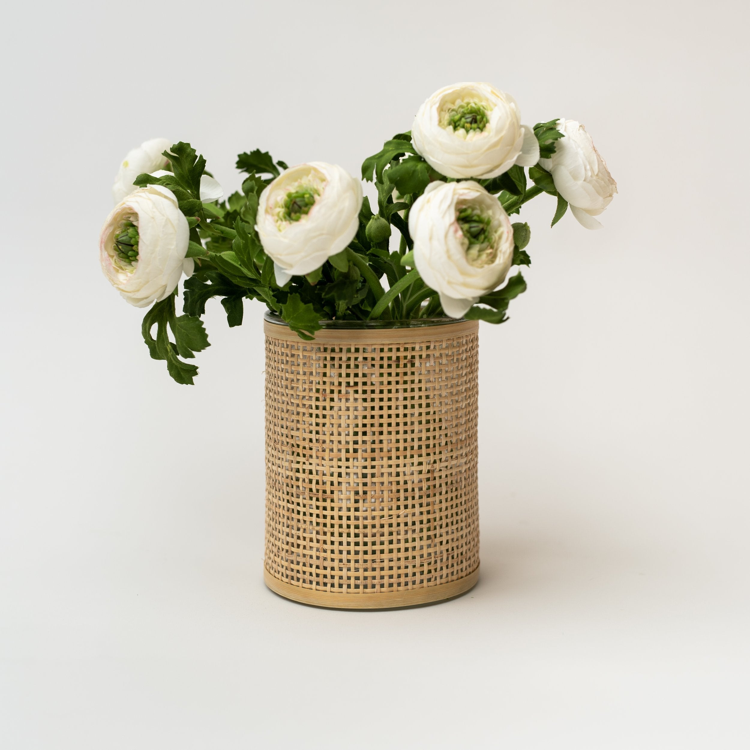 Rattan wrapped glass vase with white flowers