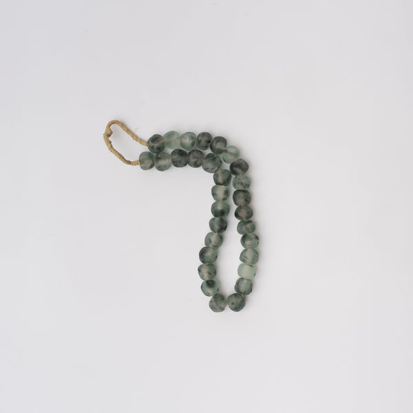 Blue grey colored decorative glass beads on a white background