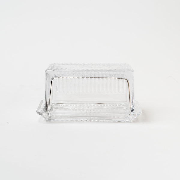 Pressed glass butter dish on a white background