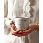 Farmhouse Pottery brand confetti heart mug being held by a model with red nails