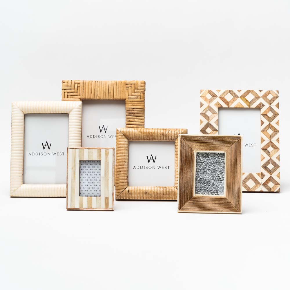 Collection of wood and cream colored picture frames on a white background 