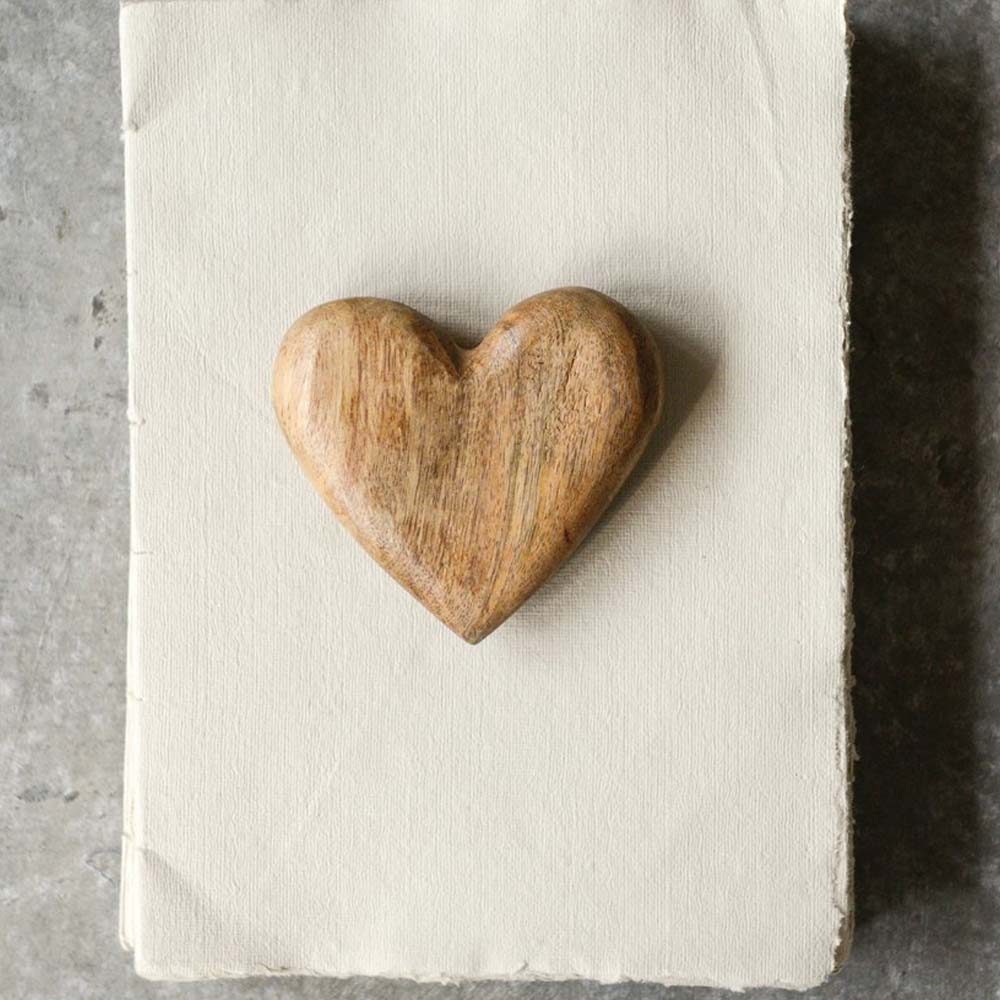 Wood hand carved heart of a rustic white paper