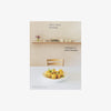 Front cover of book titled 'Home Farm Cooking' with kitchen table and bowl of lemons on a white background