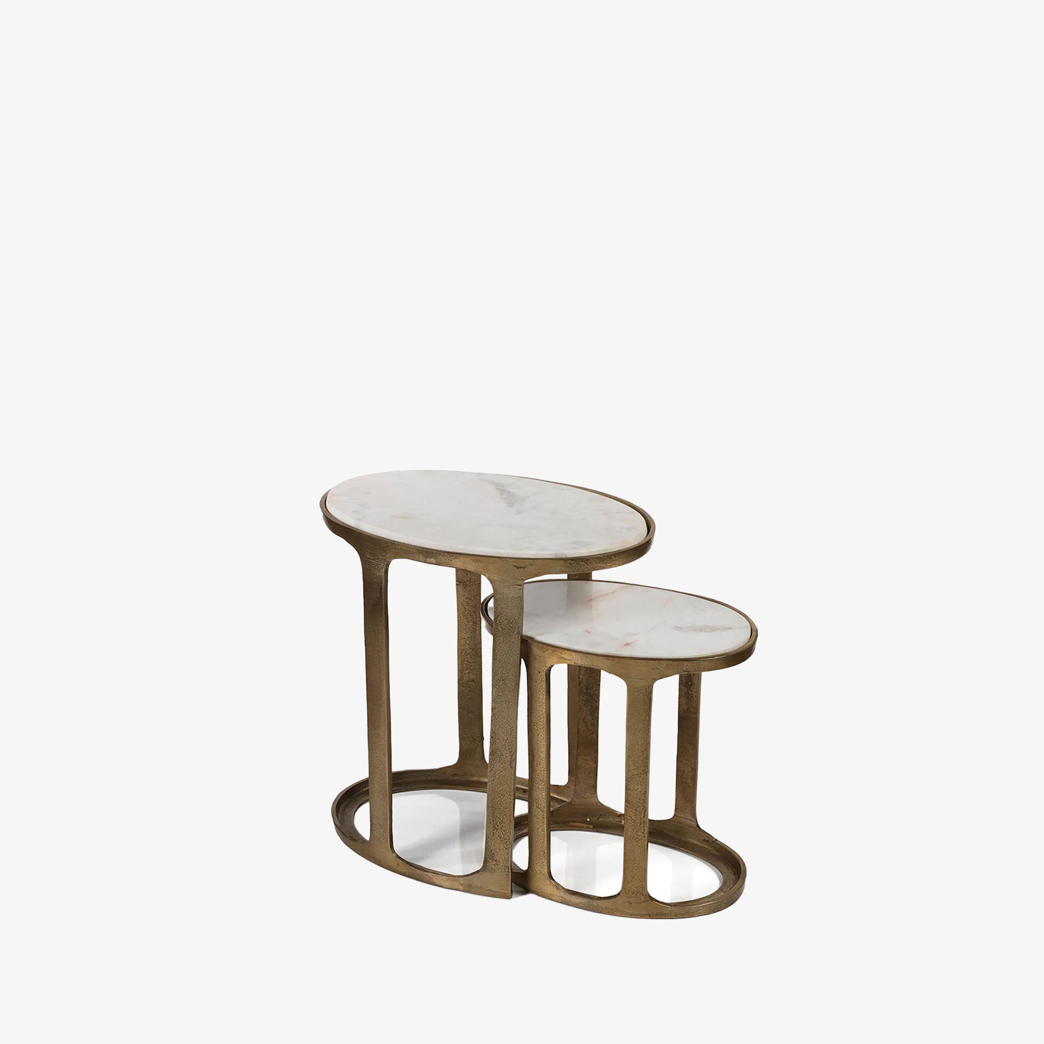 Oval brass nesting tables with marble tops on a white background