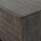 Four hands furniture brand Kelby media console with iron base and four carved doors with square brass pulls on a white background
